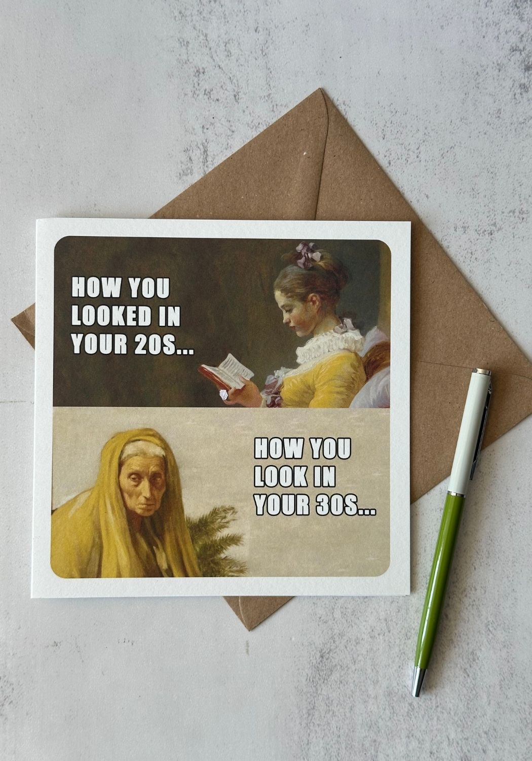 Card with vintage-style illustration and text on a textured surface with an envelope and pen.