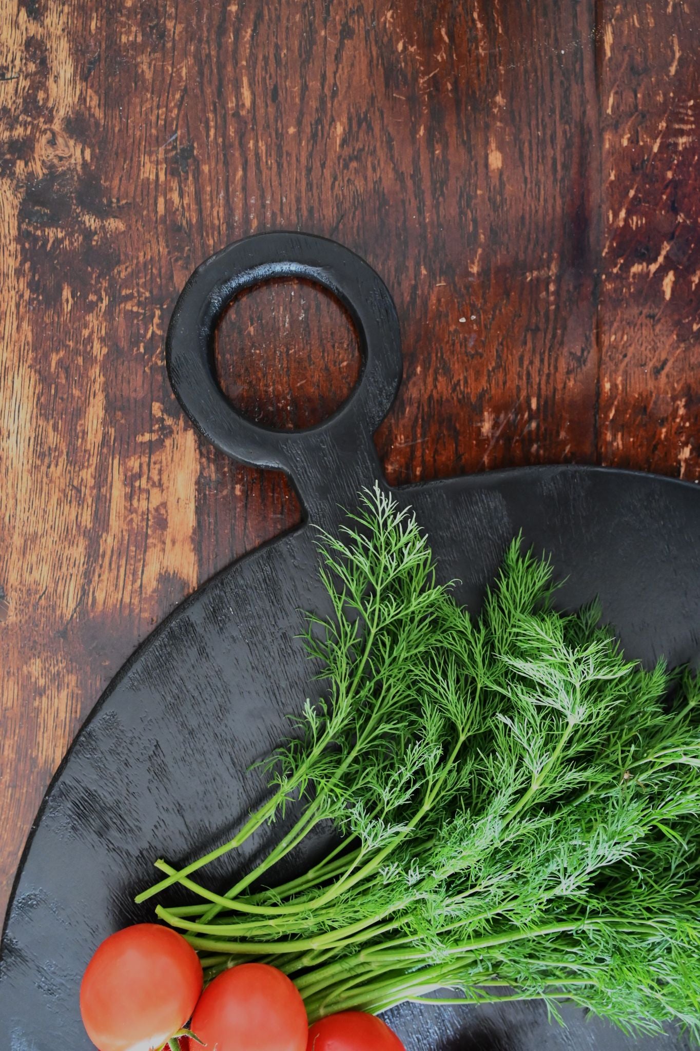 Petite planche de service ronde en bois noir