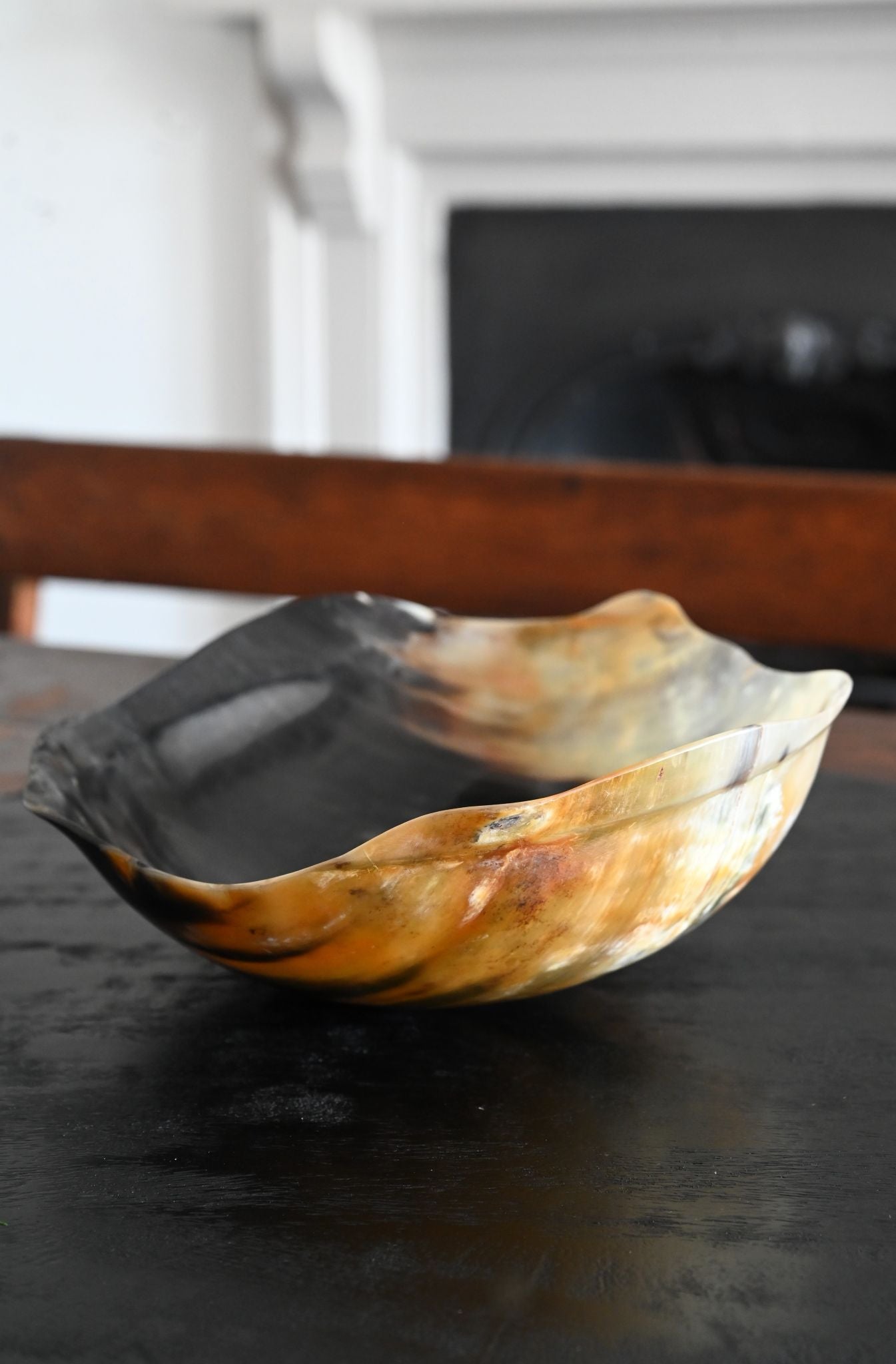 Polished variegated buffalo horn serving bowl with an asymmetrical wavy rim.