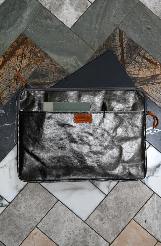 Black leather pouch with a textured surface on a marble floor