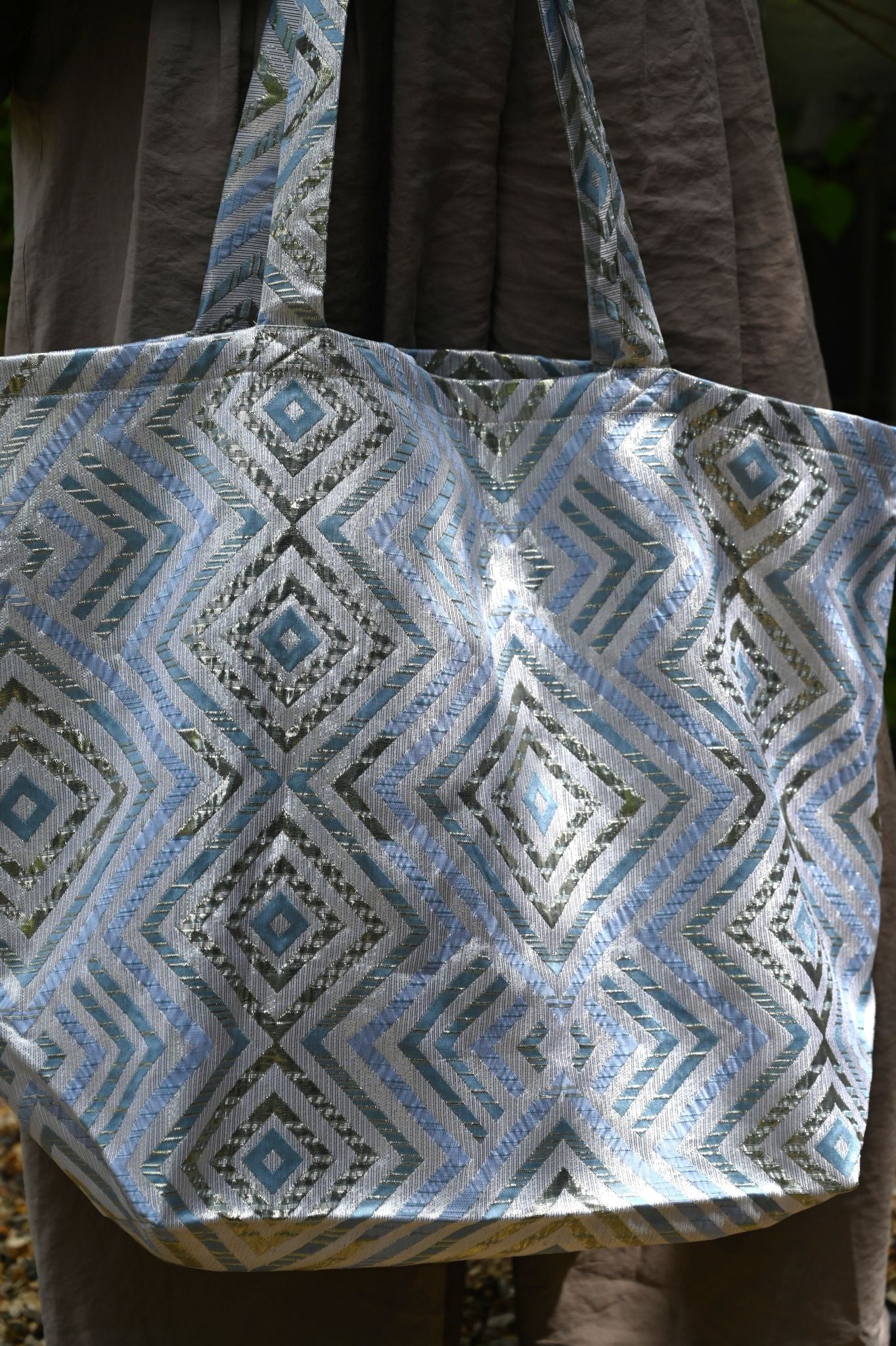 Tote bag with geometric pattern held by a person outdoors