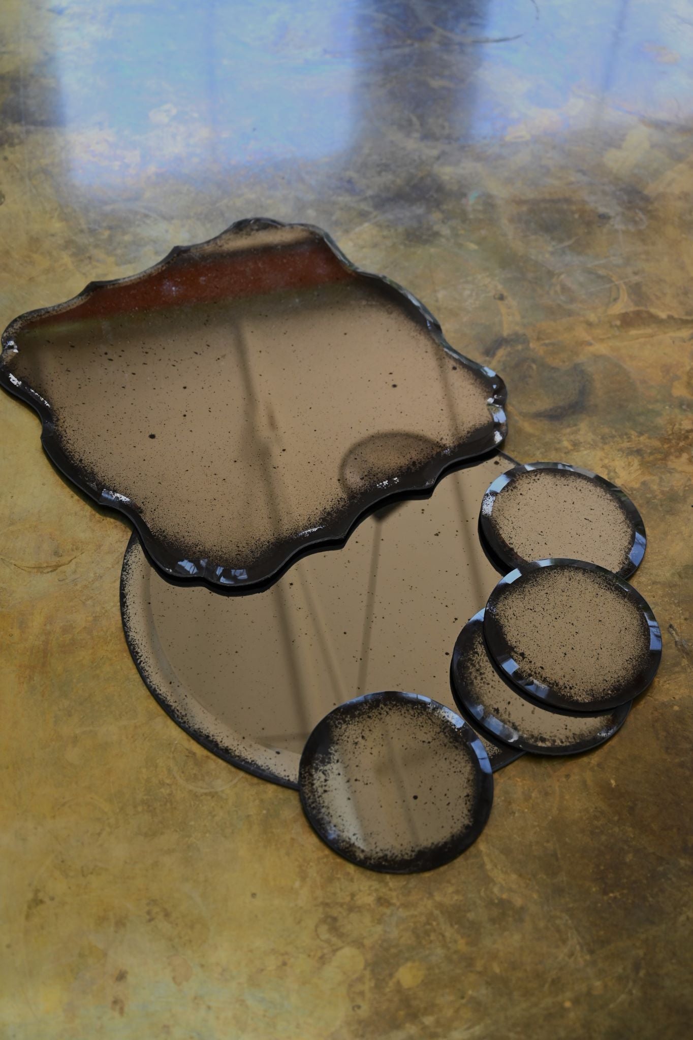 Set of four hand-gilded, bevelled mirror coasters with distressed, antique finish.