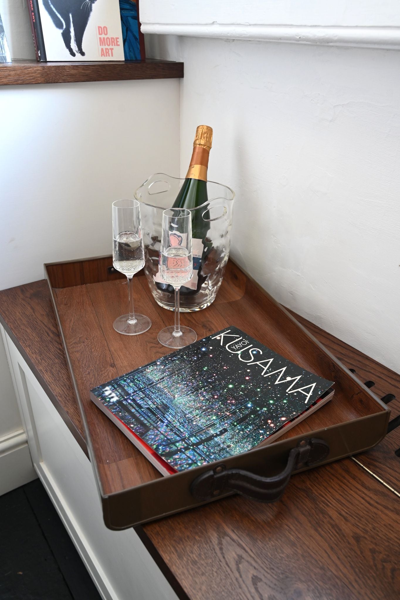 Large chocolate brown serving tray with leather handles styled for luxury entertaining.