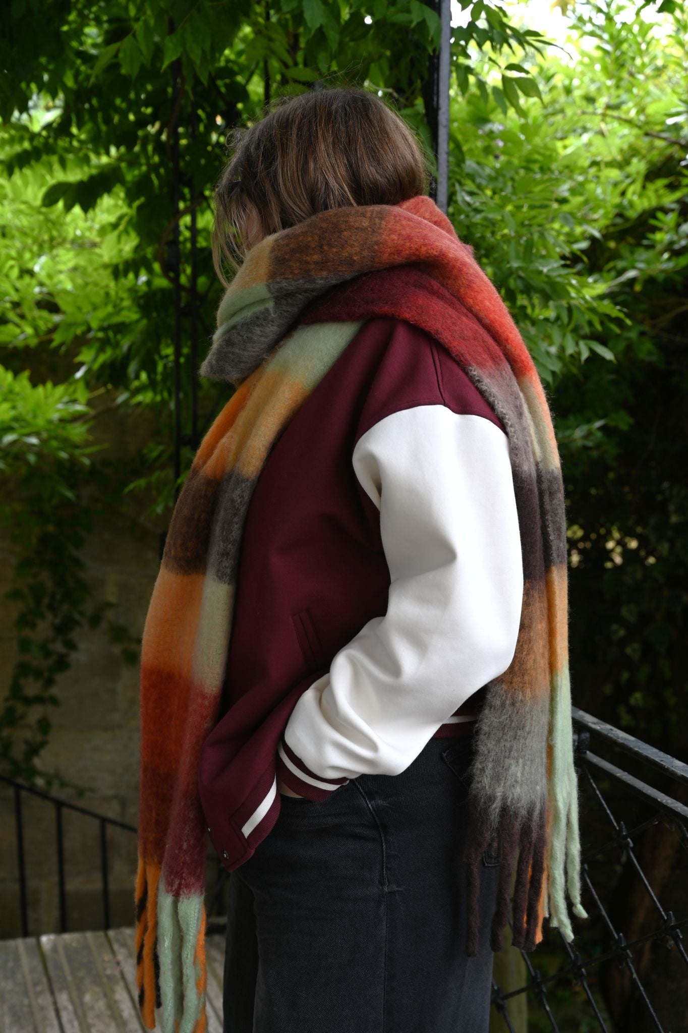 Oversized, fuzzy check scarf in red, green, and grey plaid worn outdoors.