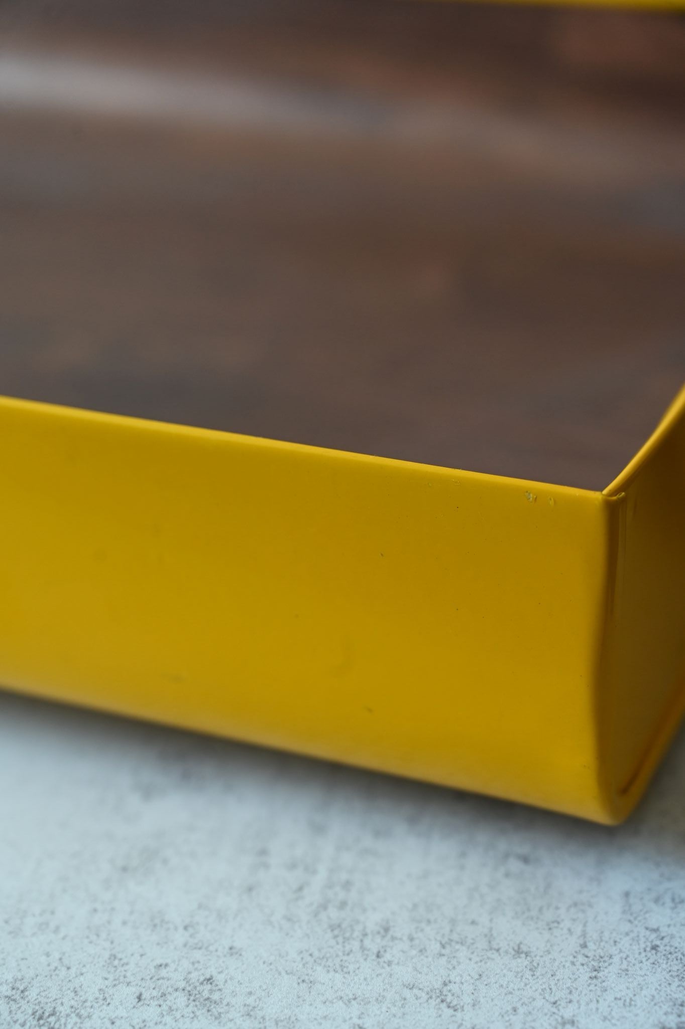 Close-up of a yellow tray on a textured surface