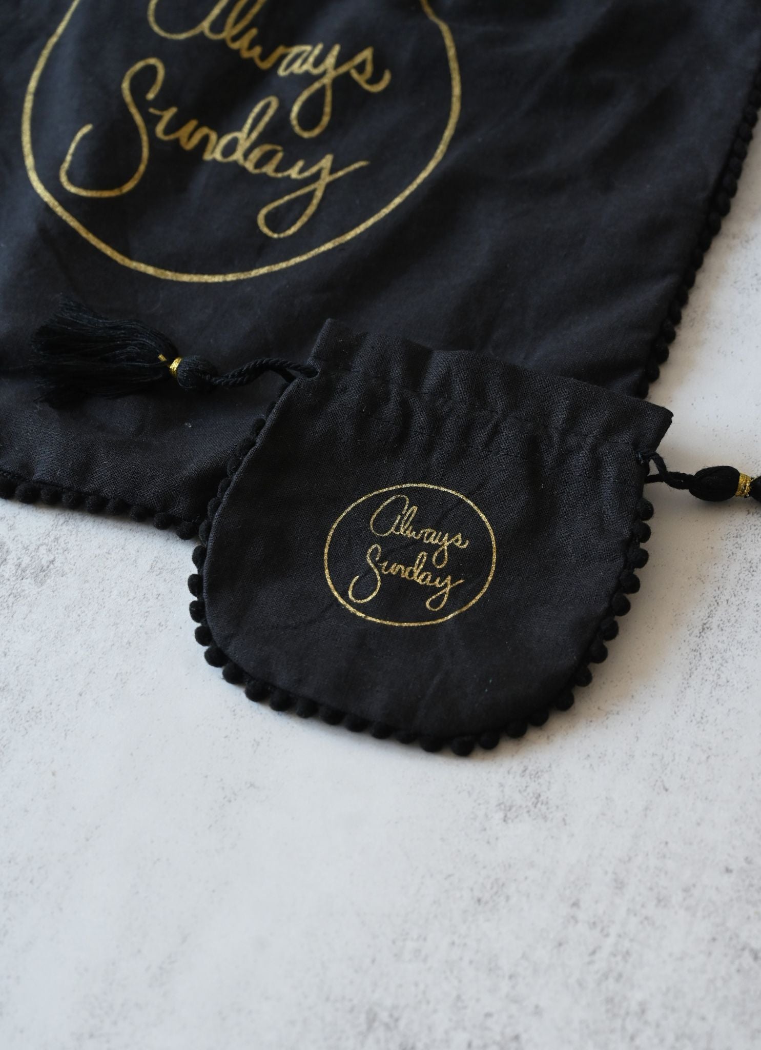 Black drawstring bag with 'Always Sunday' logo on a white background