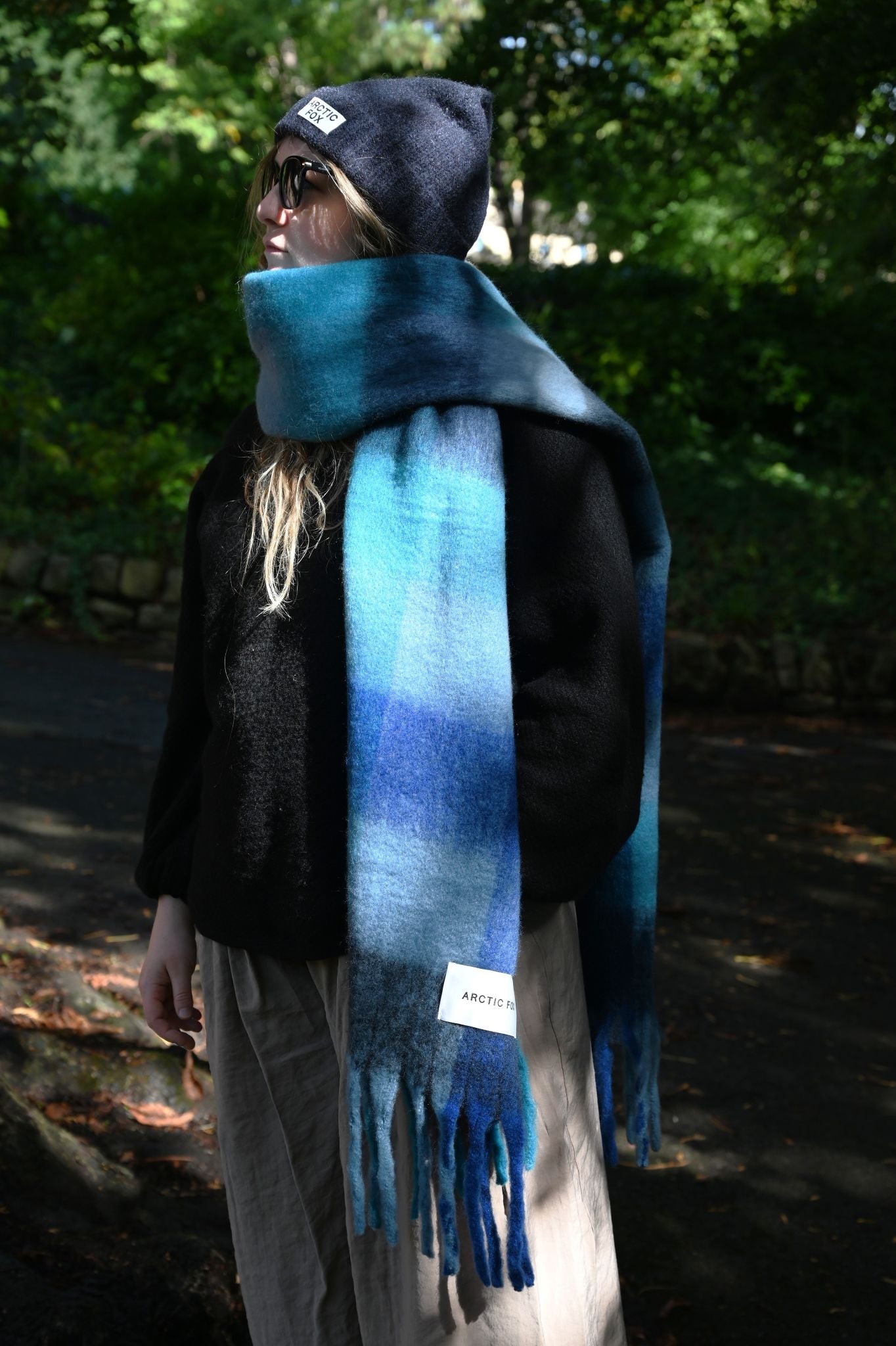 Oversized cobalt blue check brushed scarf worn with a black beanie outdoors.