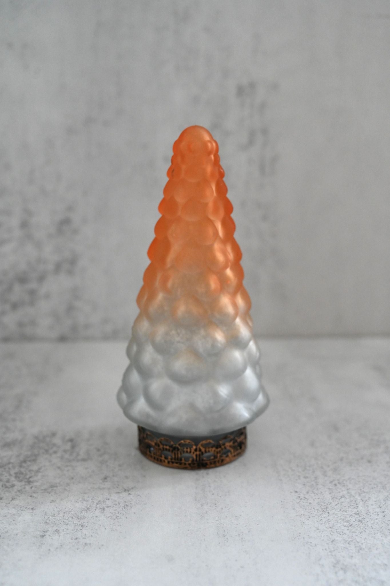Decorative glass tree with gradient color on a textured surface