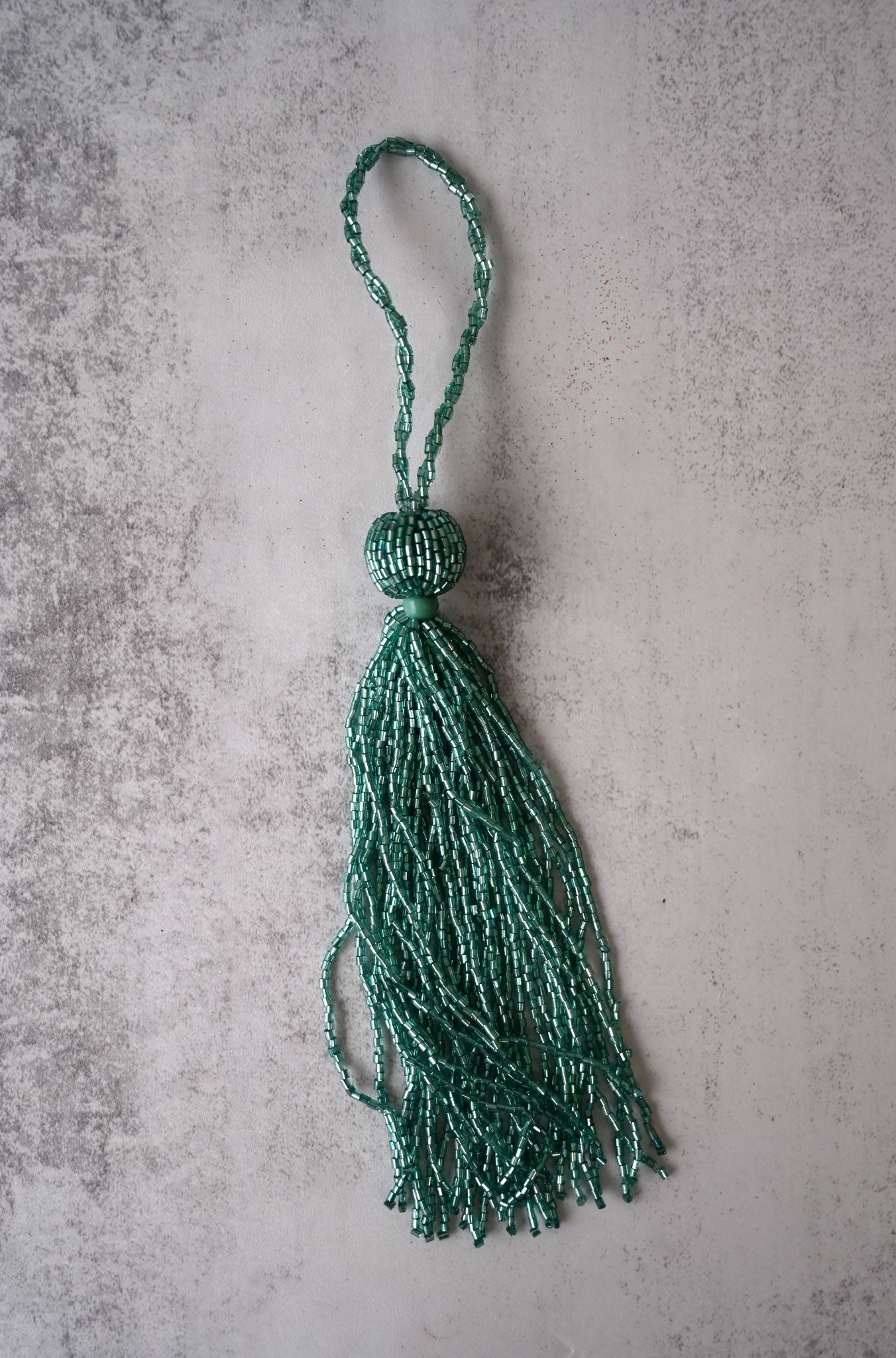 Opulent Art Deco style tassel ornament crafted from shimmering turquoise glass beads.
