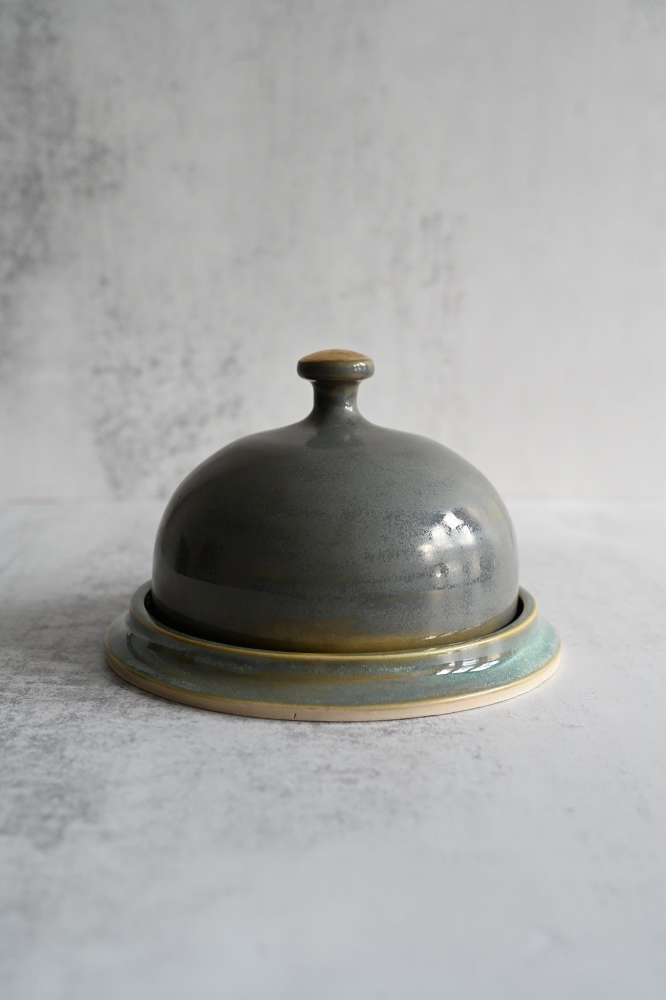 Hand-thrown ceramic butter dish with sea green glaze and gold-brushed lid.