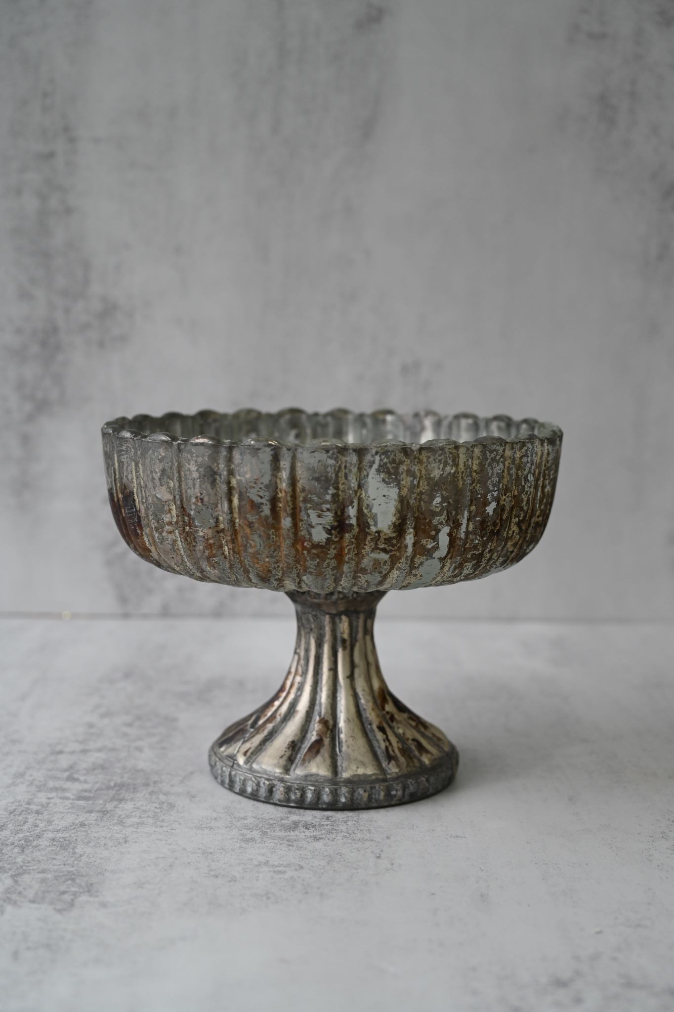 Large antique silver mercury glass pedestal bowl with a fluted base and scalloped rim.