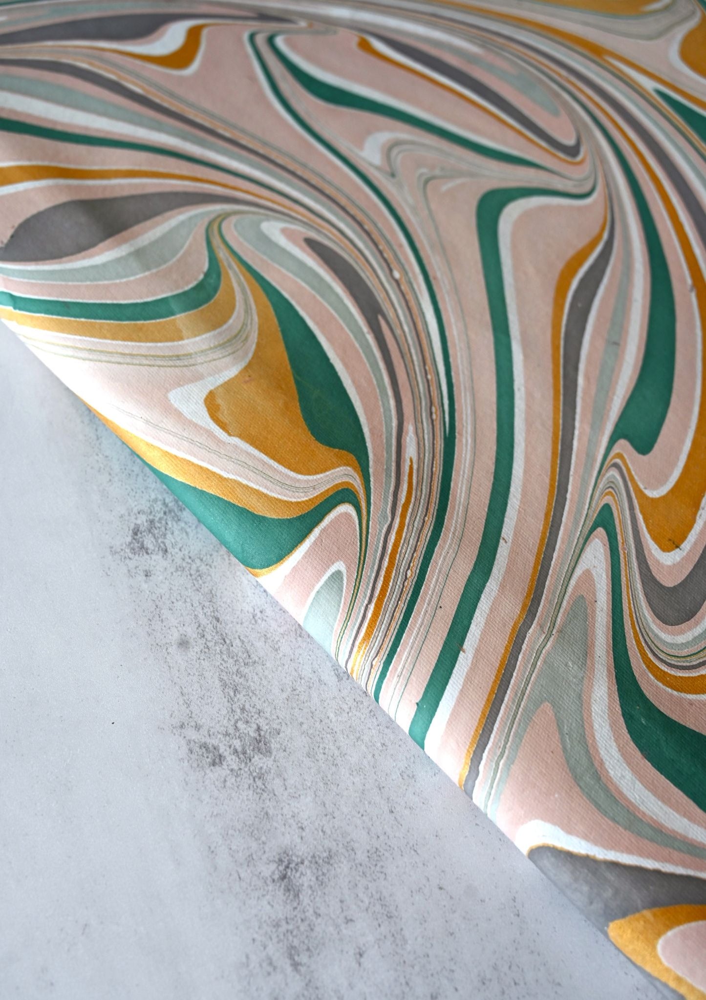 Close-up of pink and green swirl hand-marbled luxury wrapping paper.