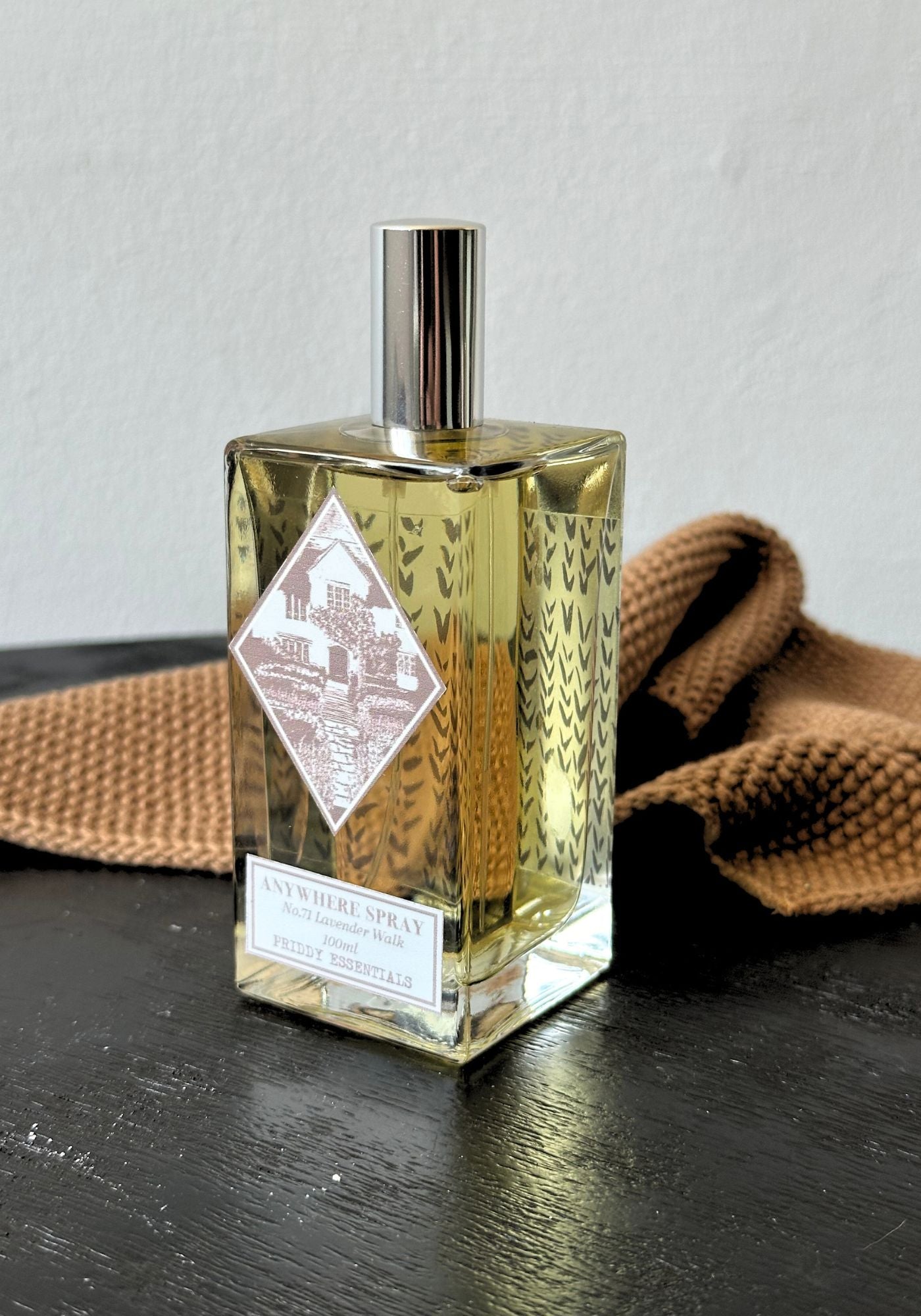 Glass bottle with a label on a dark surface with a brown textured fabric background