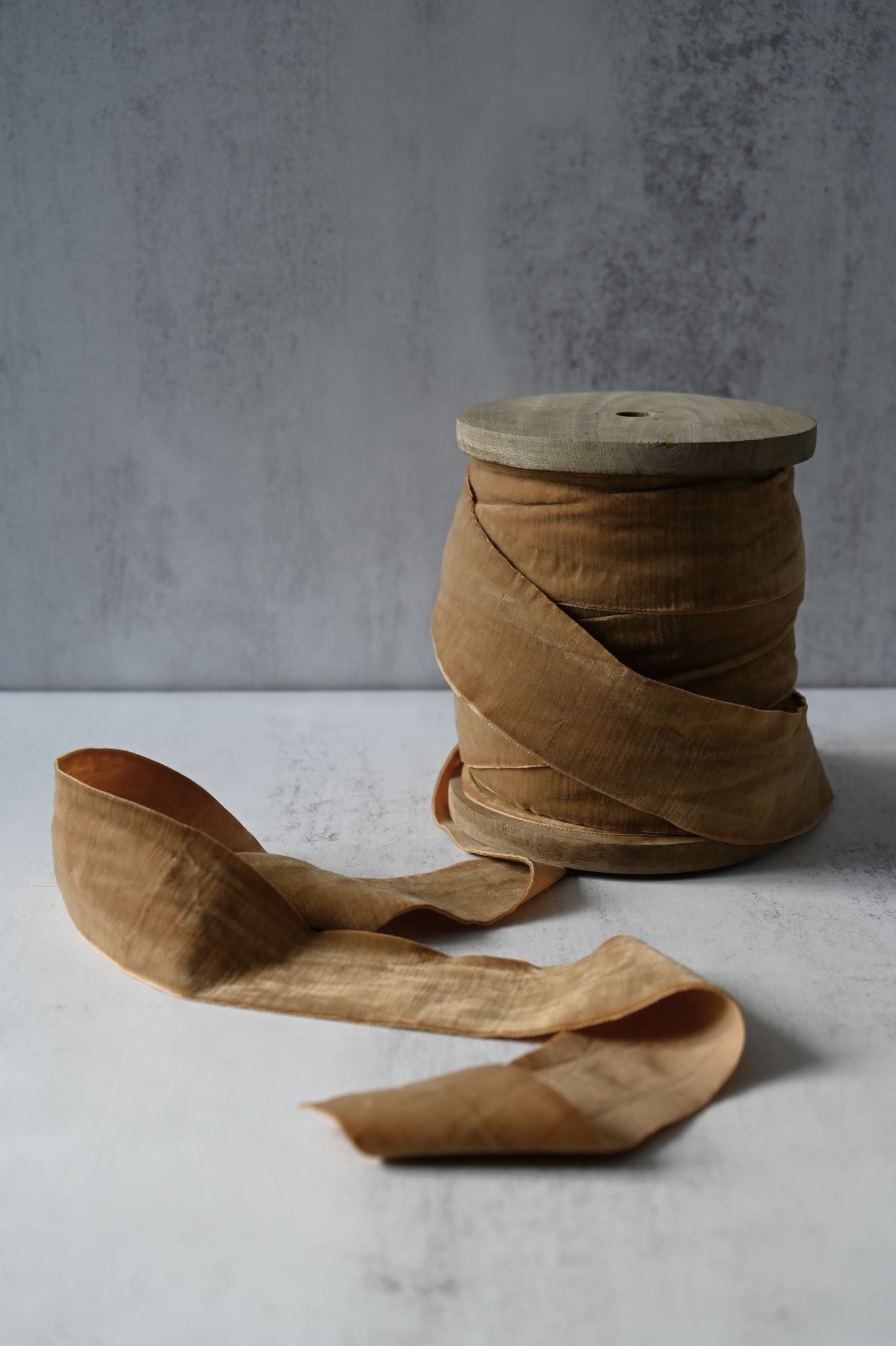 Wide honey mustard cotton velvet ribbon spool for luxury gift wrapping.