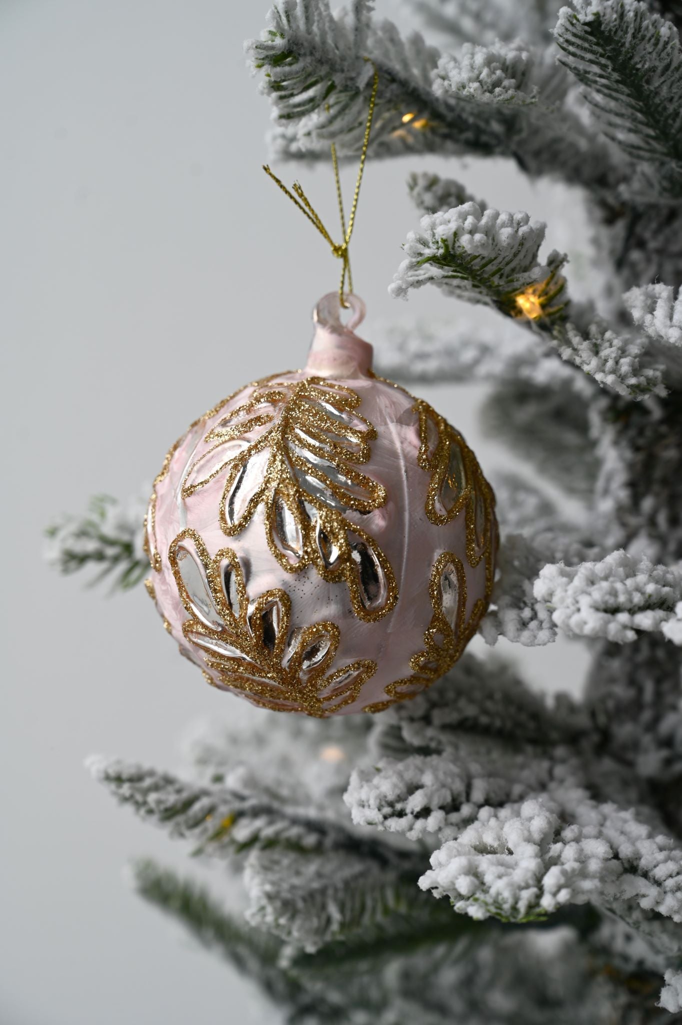 Rosa Christbaumkugel mit goldenen Blättern
