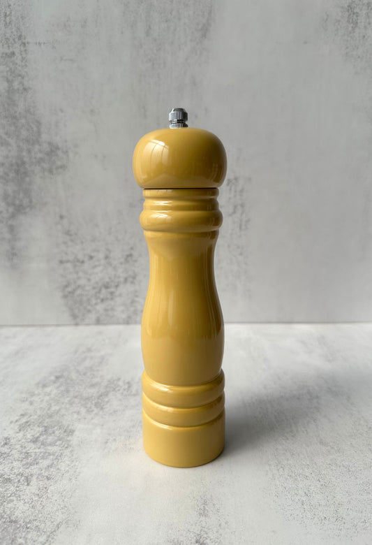 A row of colourful, glossy rubber wood salt and pepper mills in classic hourglass shapes.