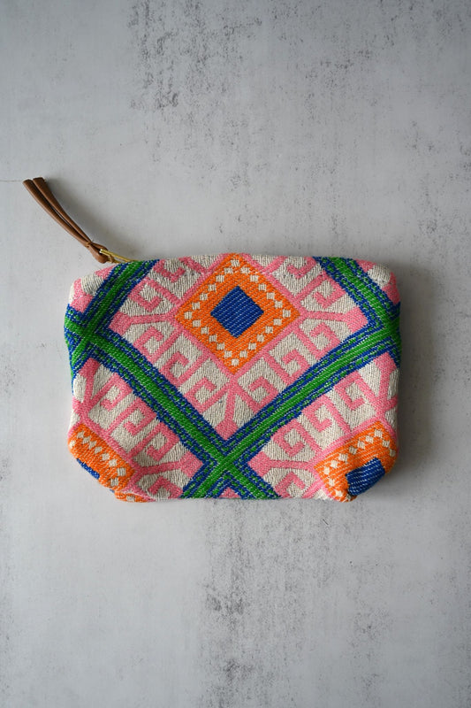 Pink and green Moorish tile print woven pouch with a tan tassel zipper pull.