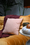 Square peach pink linen cushions on a sofa