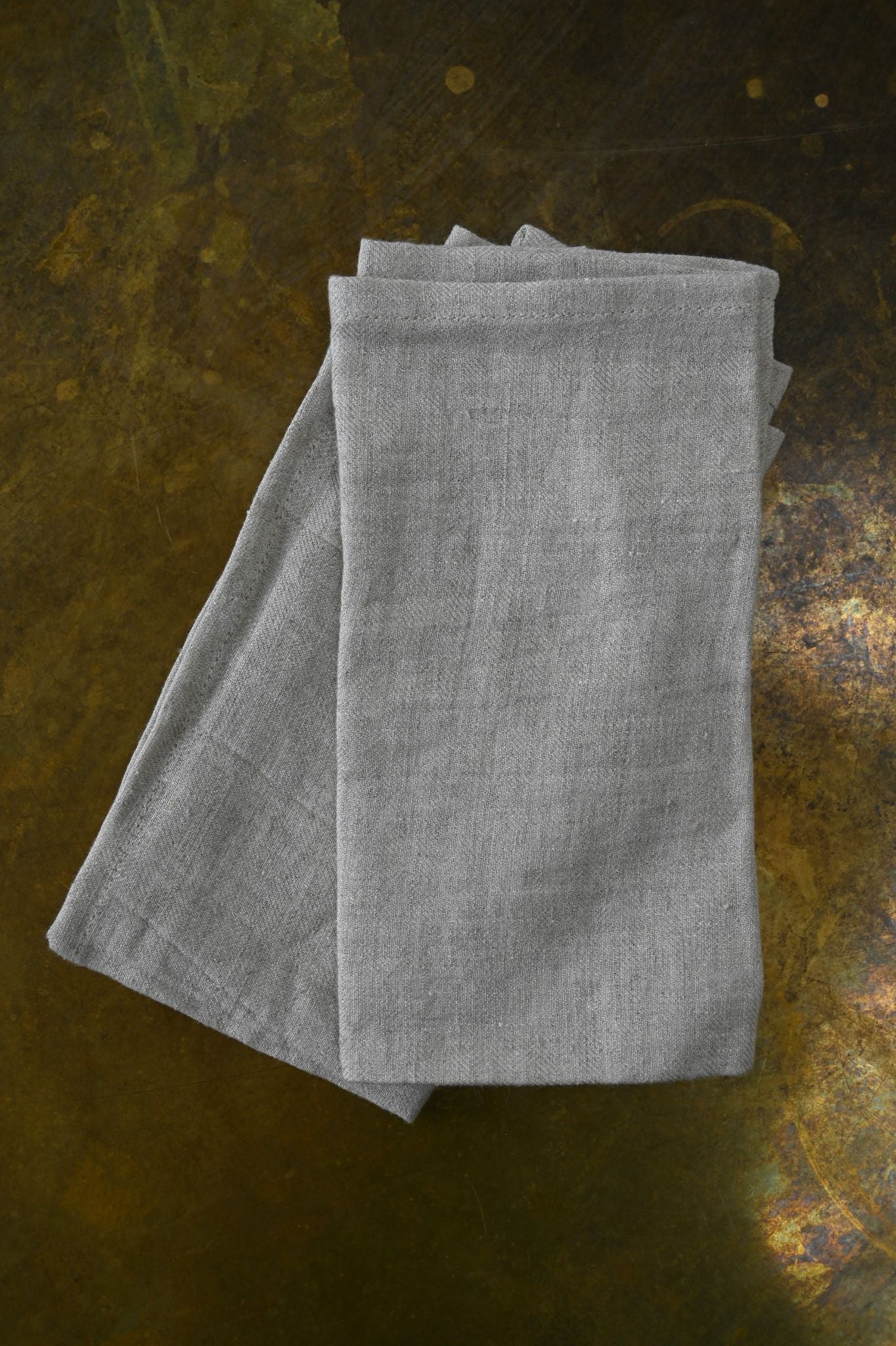 Folded gray napkin on a textured dark surface