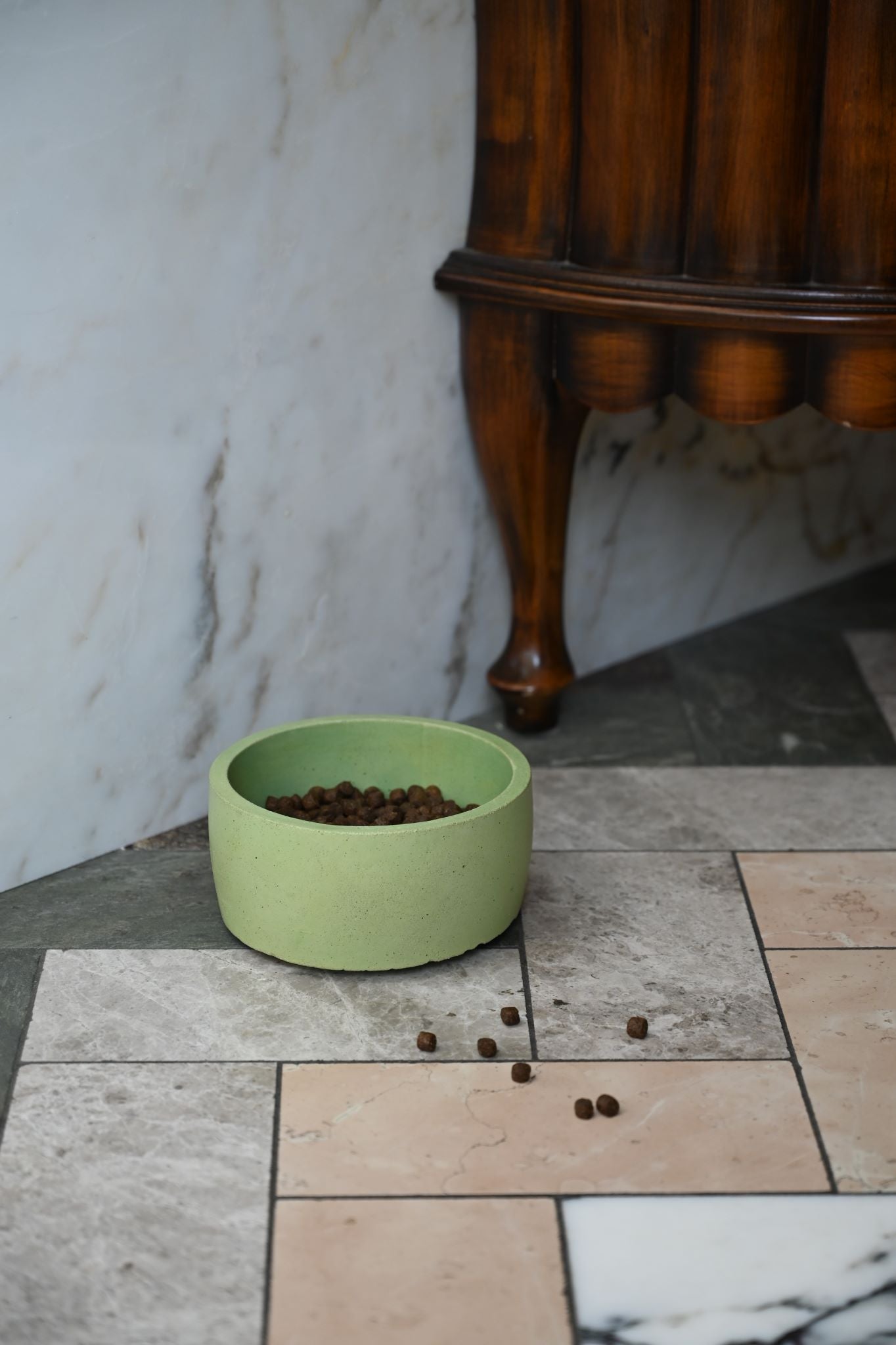 Stacked handcrafted concrete dog bowls in muted earthy tones with a matte finish.