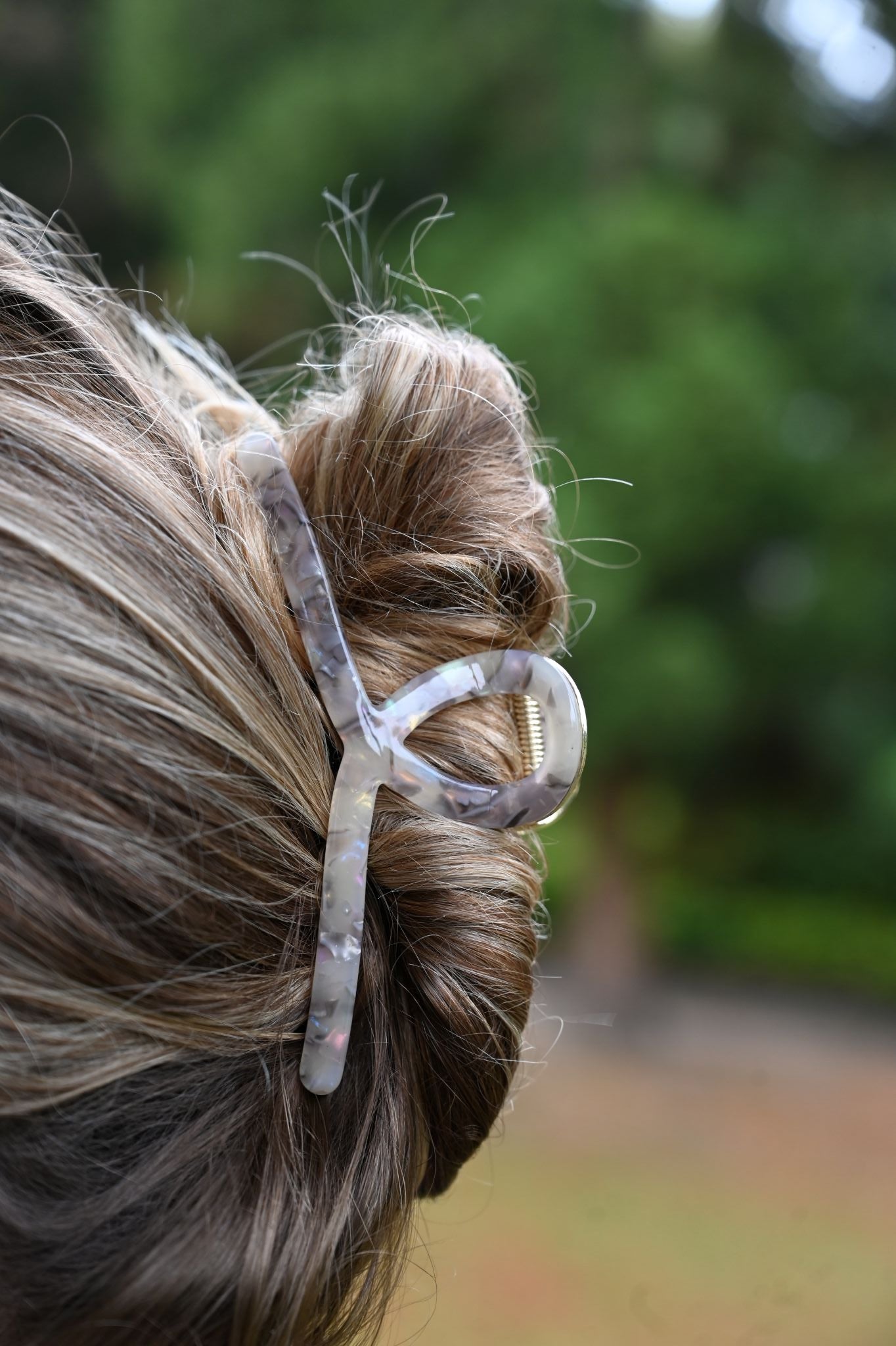 Close-up of a hair clip in a person's hair with a blurred natural background