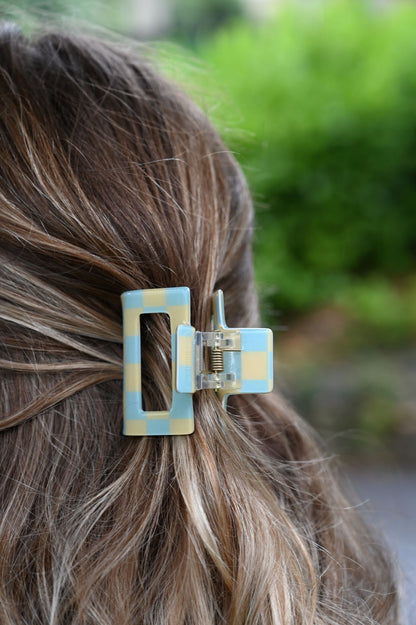 Close-up of a hair clip in a person's hair with a blurred green background