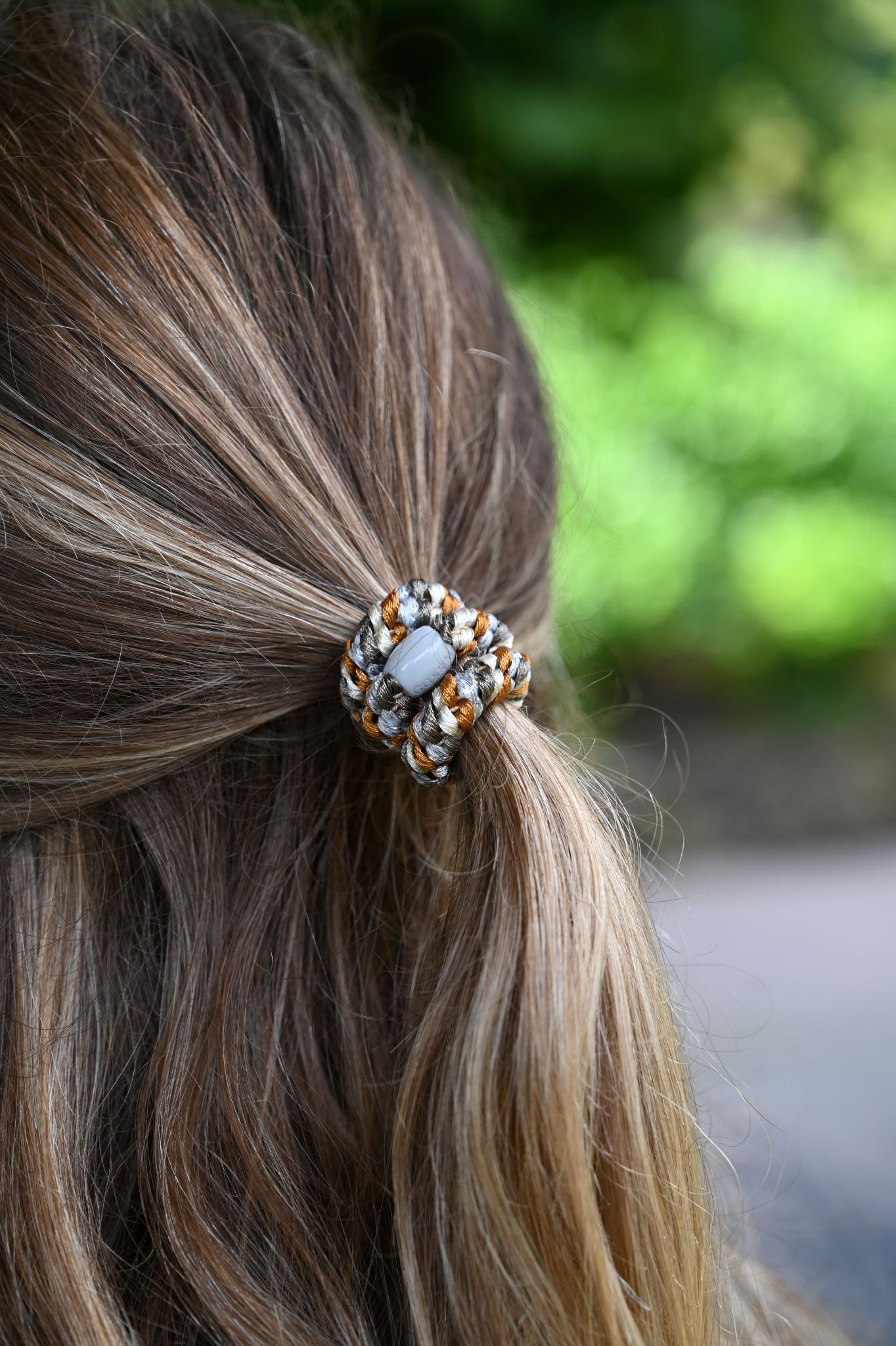 Close-up of a hair tie with a blurred green background