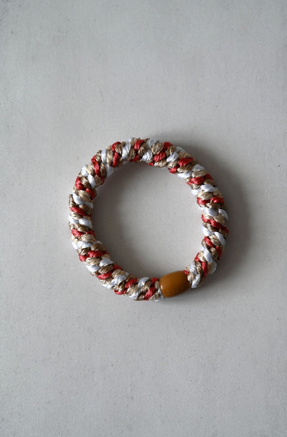 Bracelet with red, white, and brown colors on a gray background