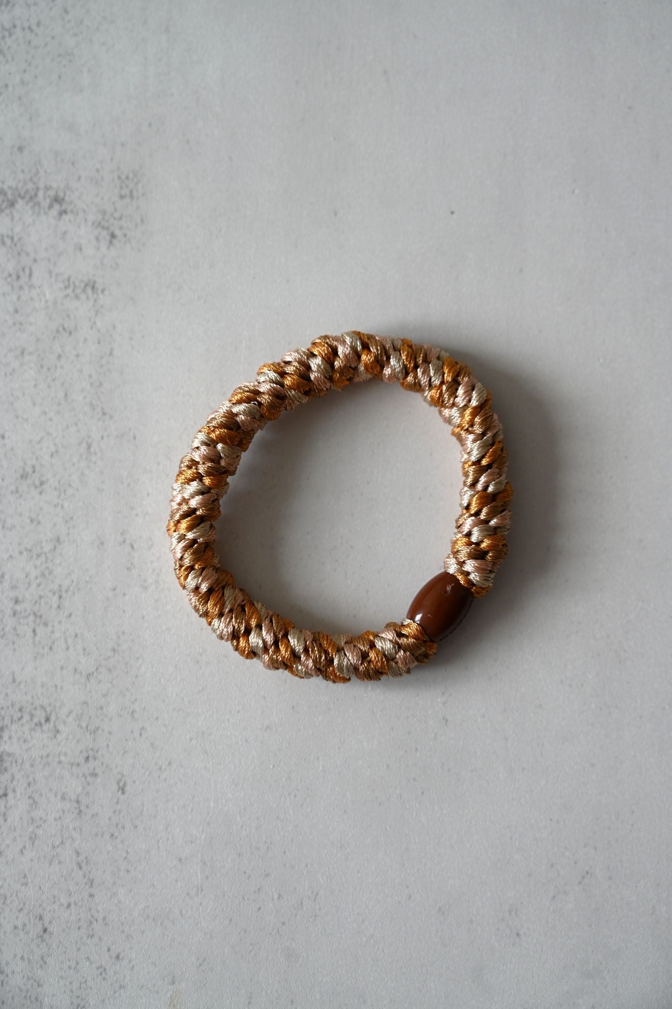 Woven bracelet on a textured gray surface
