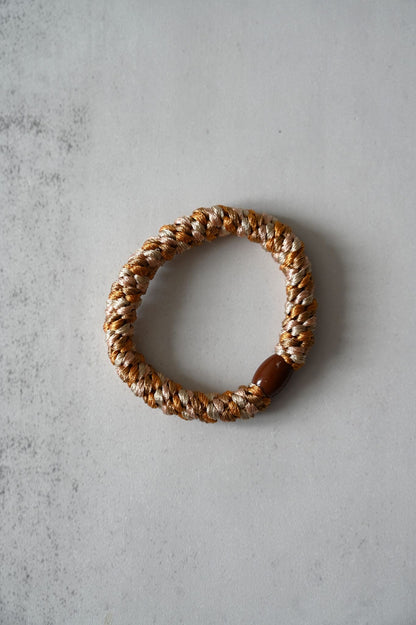 Woven bracelet on a textured gray surface