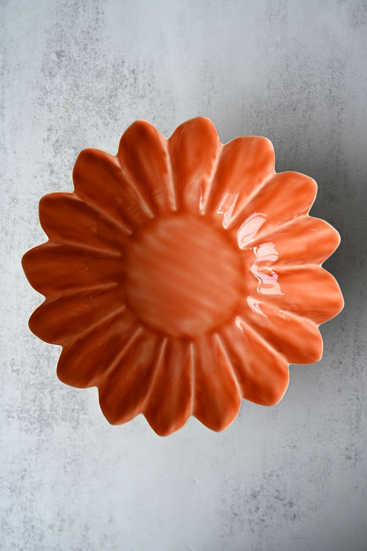 Three orange and yellow hand-painted metal bowls with scalloped edges stacked together.