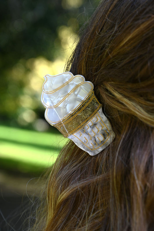 Decorative ice cream hair clip in a girls hair on a blurred natural background