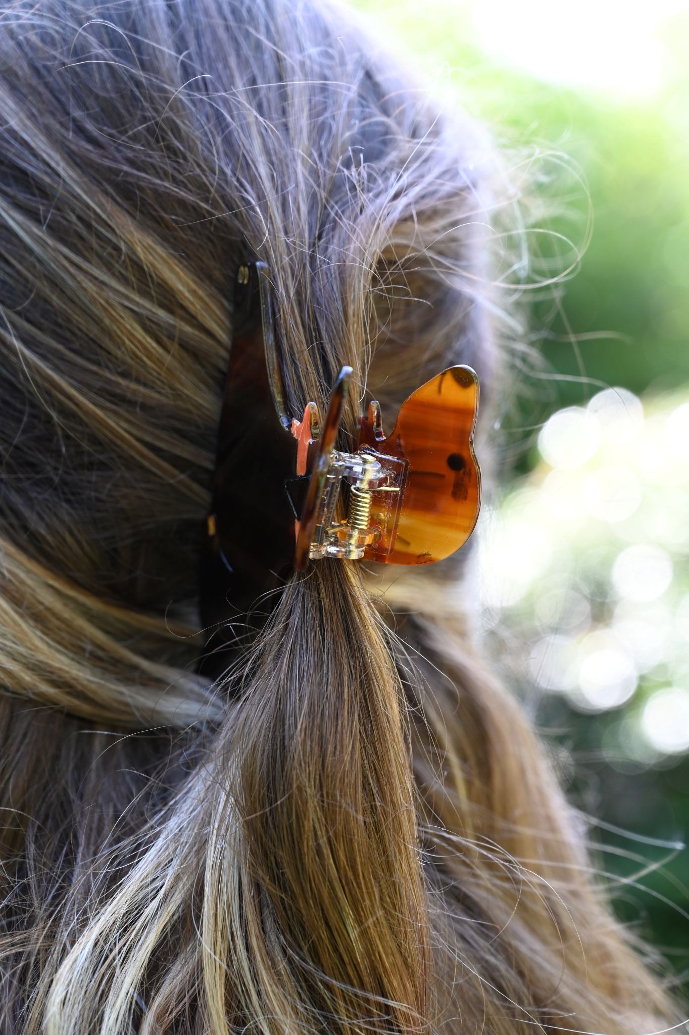Close-up of a sausage dog hair clip in a person's hair with a blurred natural background