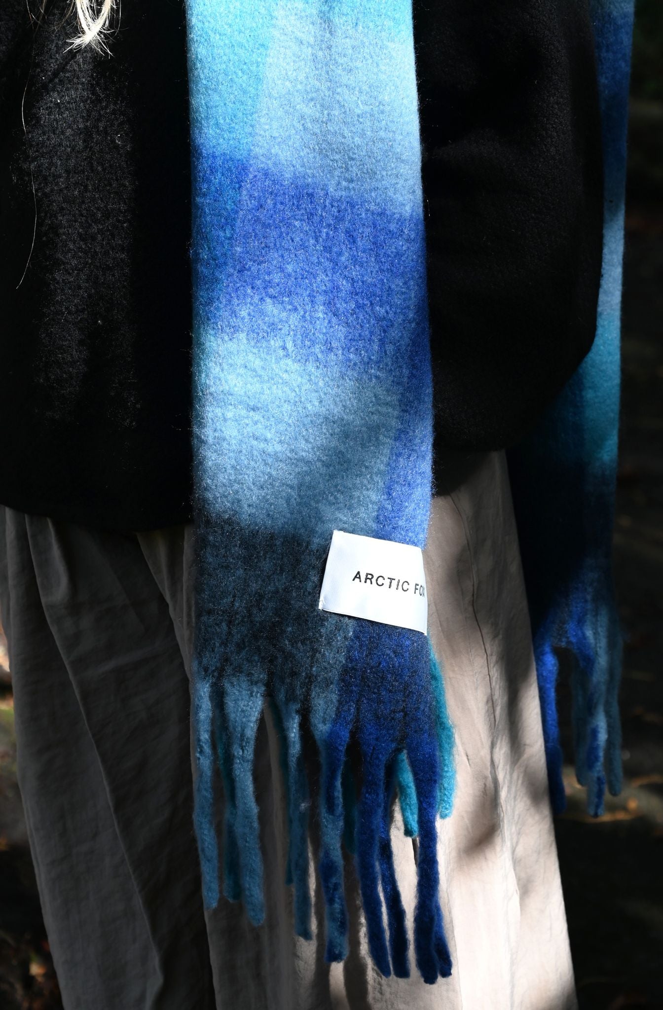 Blue scarf with a brand tag on a blurred background