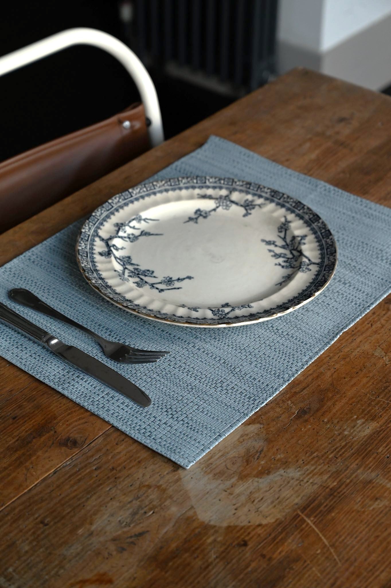 Plated dish with silverware on a wooden table with a blue placemat