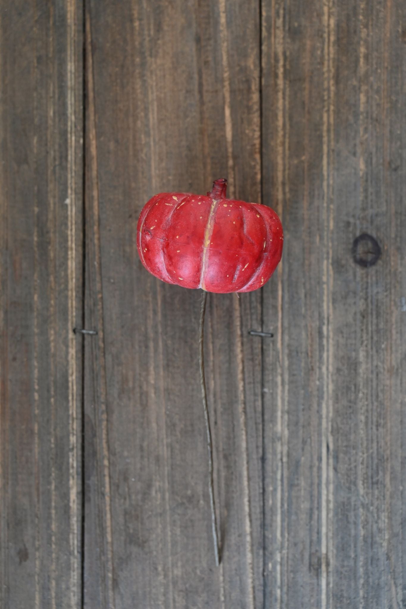 Red decorative pumpkin on a wooden surface