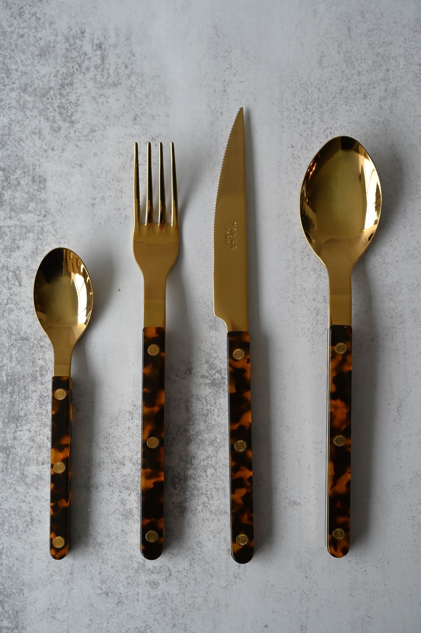 Sabre vintage bistro cutlery set featuring matte black metal and peach riveted acrylic handles.