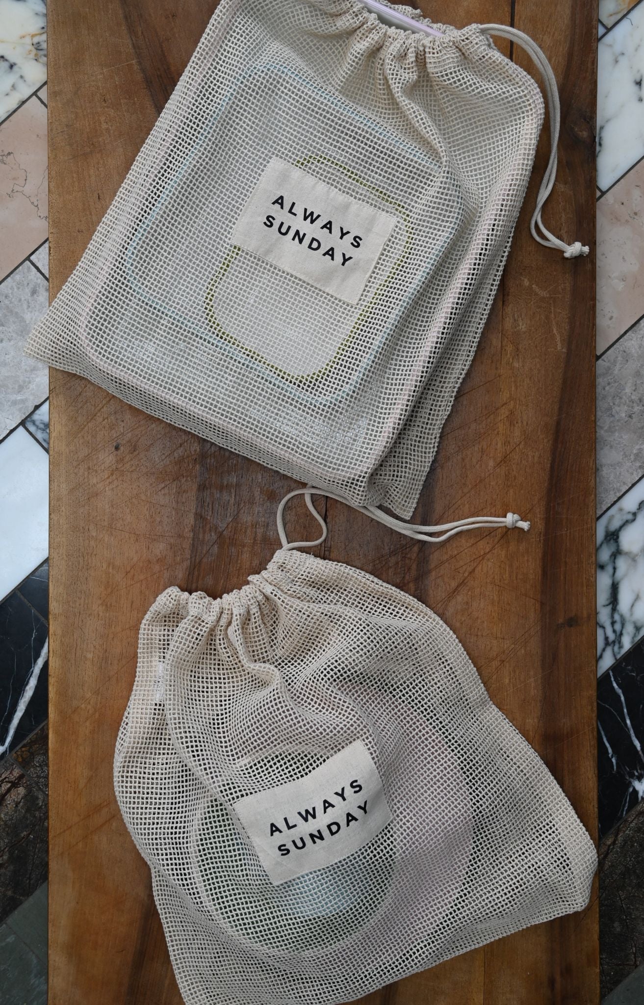 Two mesh bags with 'Always Sunday' label on a wooden surface.