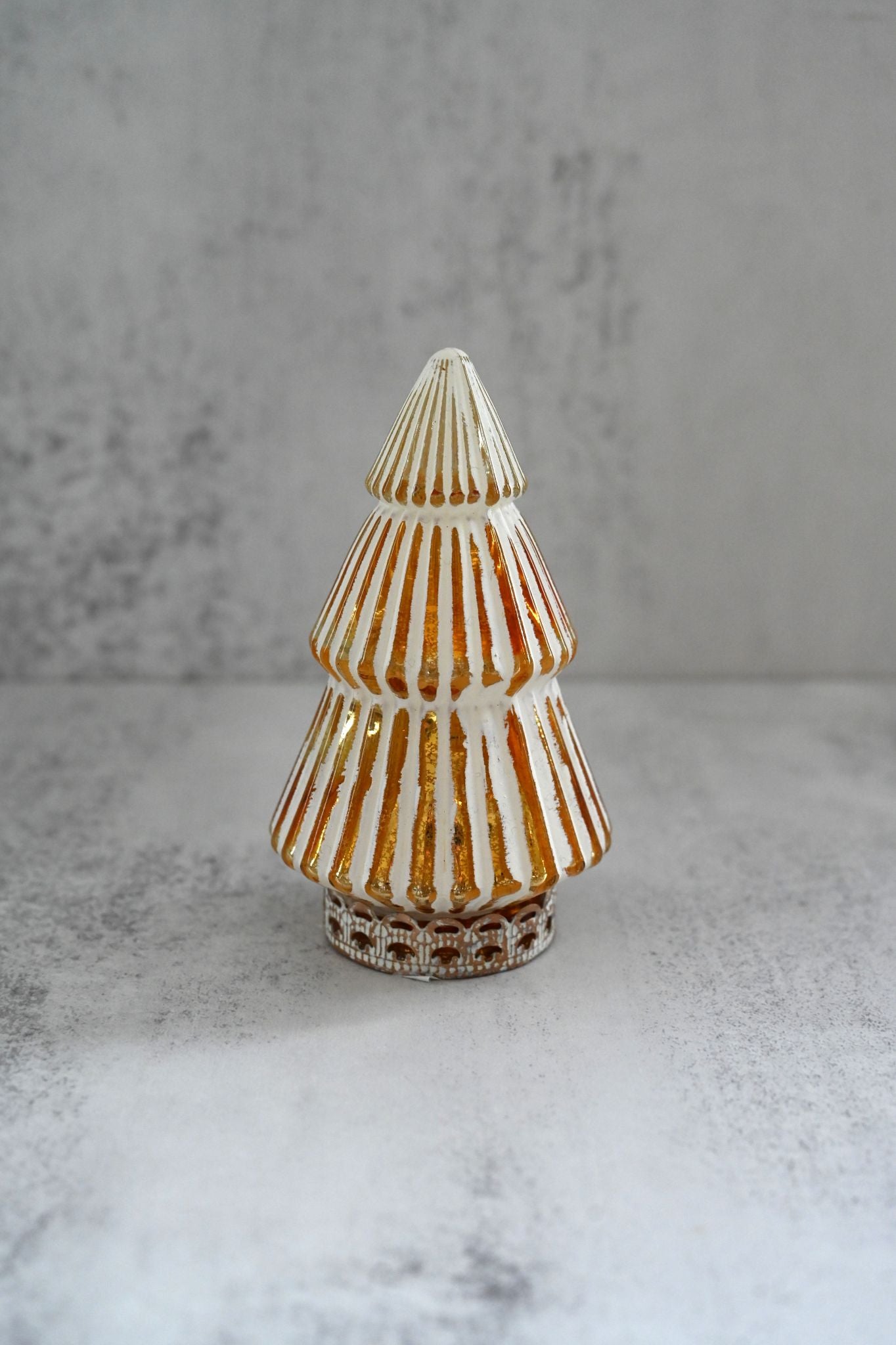 Decorative glass tree with striped pattern on a gray surface