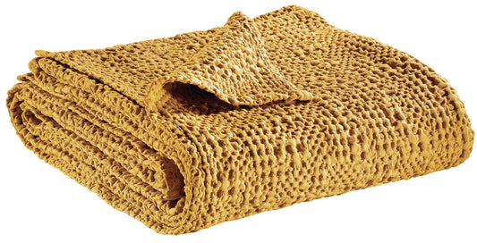 Stacked stonewashed cotton waffle throws in pink, coral, and mustard yellow.