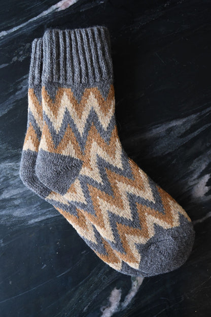 Thick knit winter socks with geometric zigzag pattern in grey and tan colours.
