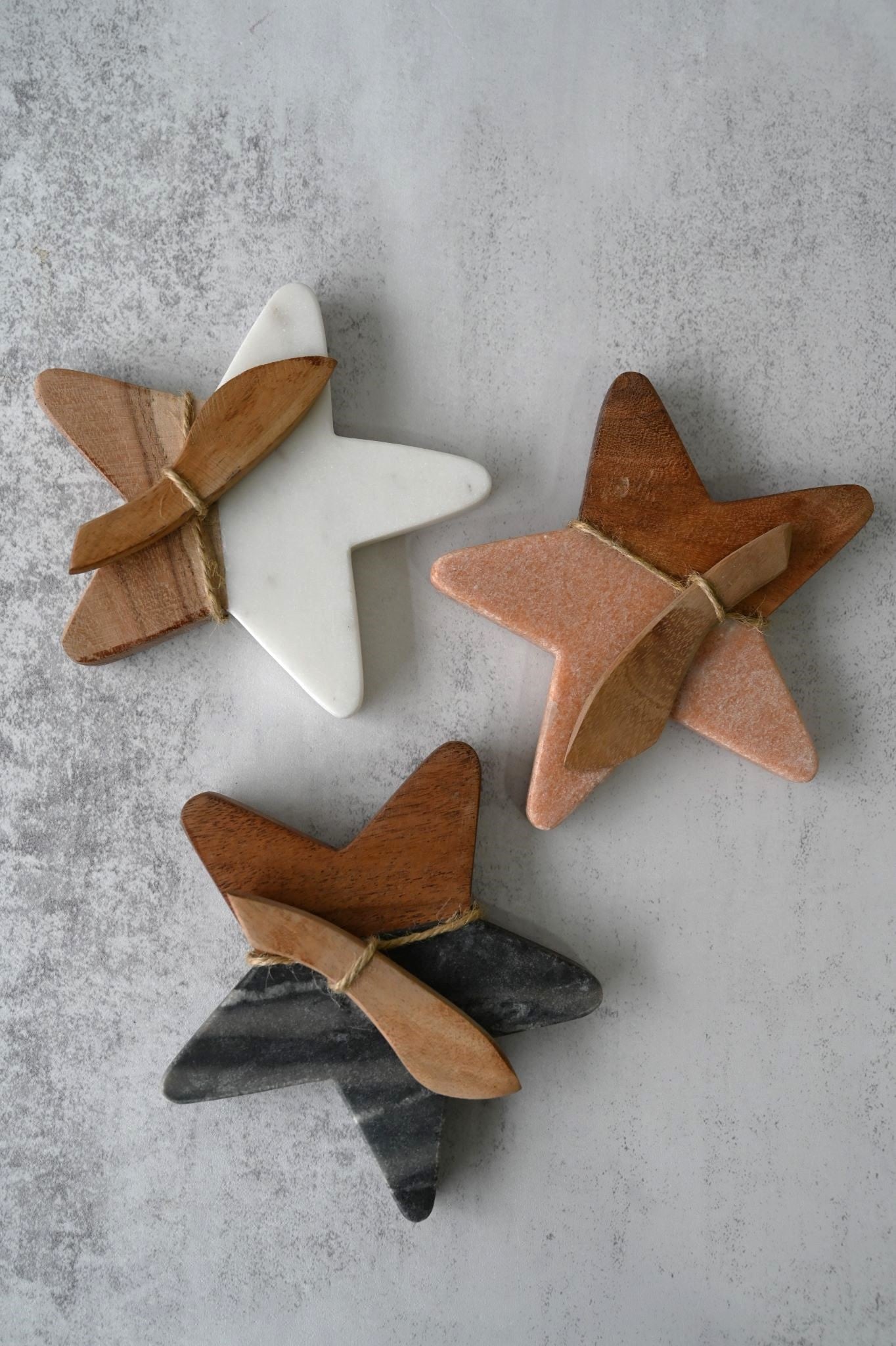 Set of three star-shaped marble and wood mini serving boards with spreaders.