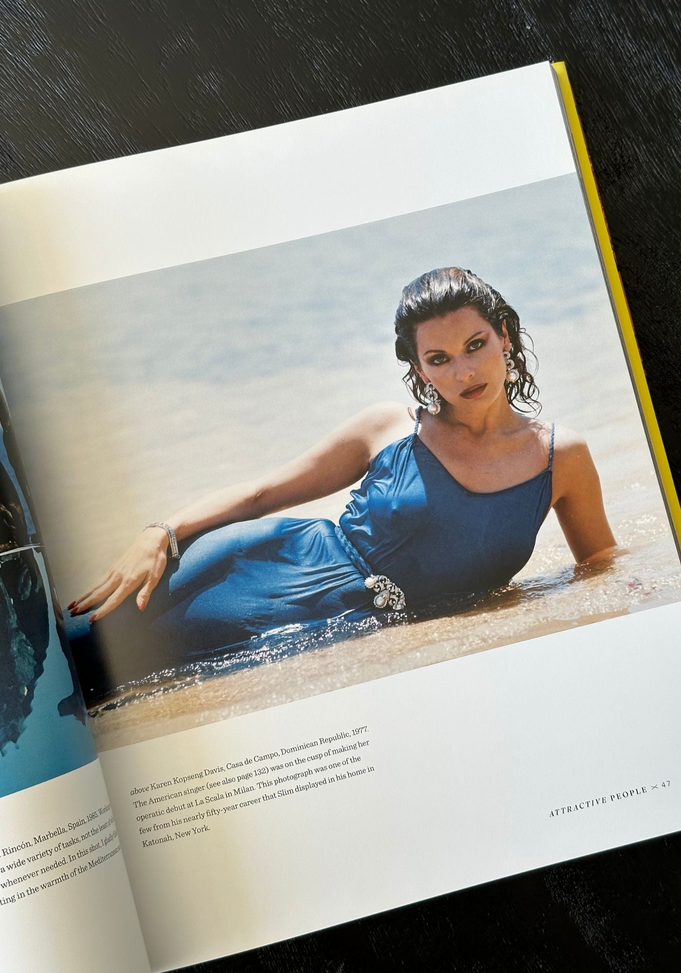 Open book showing a woman in a blue dress sitting in water.