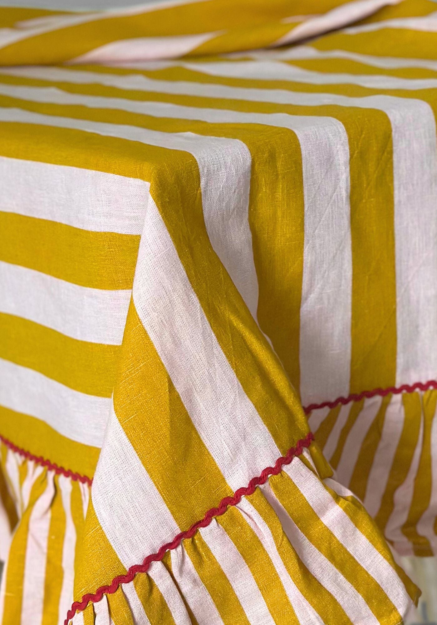 Yellow and white striped fabric with red trim