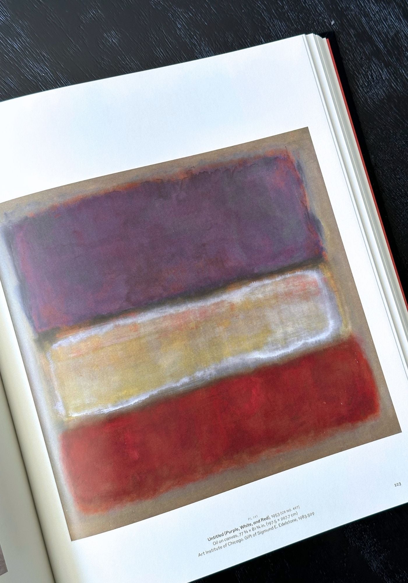 Abstract art book with three horizontal color blocks on a dark surface