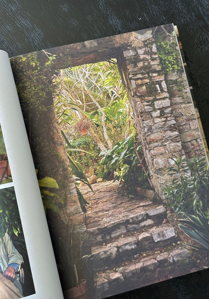 Stone pathway leading through a stone archway into a lush green garden.