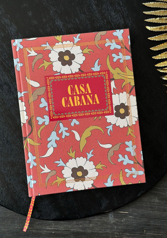 Notebook with floral design and 'Casa Cabana' text on a dark surface