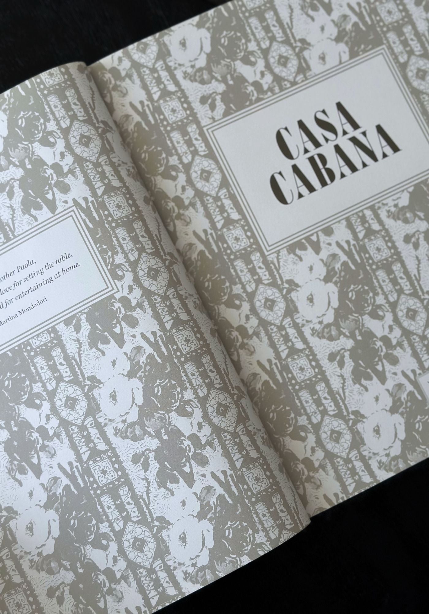 Open book with 'Casa Cabana' design on a black background