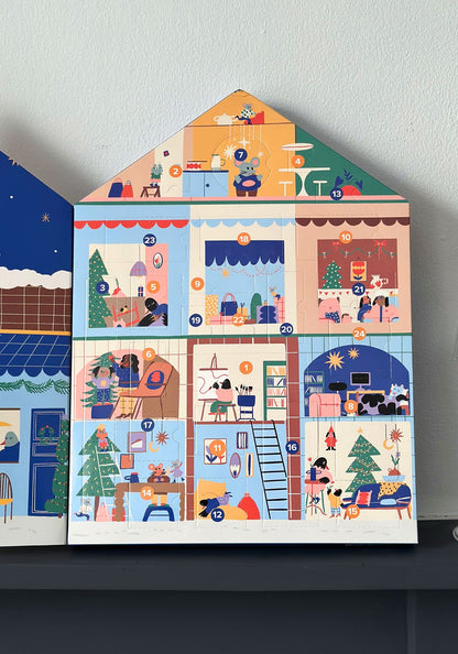 Children's house-shaped calendar with illustrated scenes on a white wall.